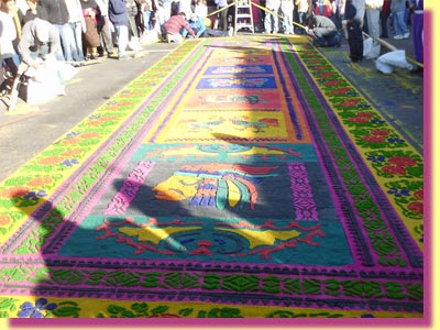 Yet another carpet on Calle Ancha, with a Mayan head in the foreground ... click to see a large image